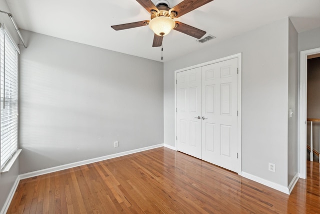 unfurnished bedroom with hardwood / wood-style flooring, ceiling fan, and a closet