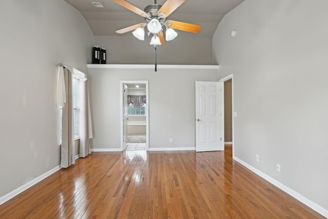 unfurnished bedroom with hardwood / wood-style flooring, ensuite bath, high vaulted ceiling, and ceiling fan