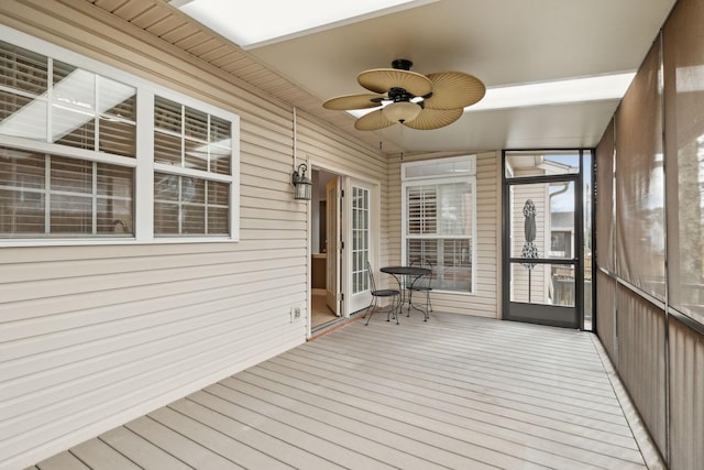 unfurnished sunroom featuring ceiling fan