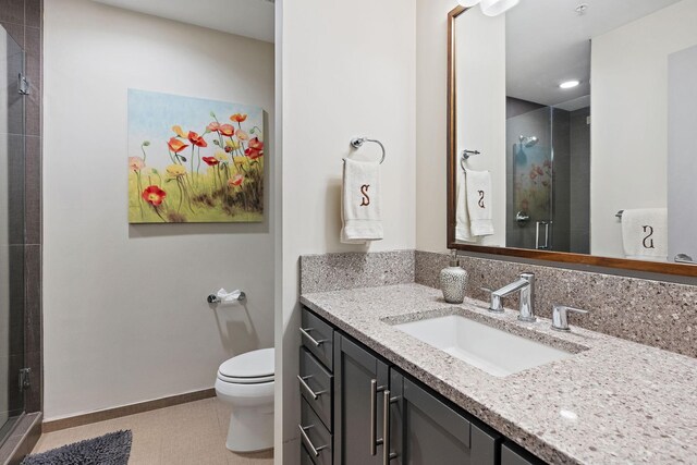 bathroom featuring tile patterned floors, vanity, an enclosed shower, and toilet