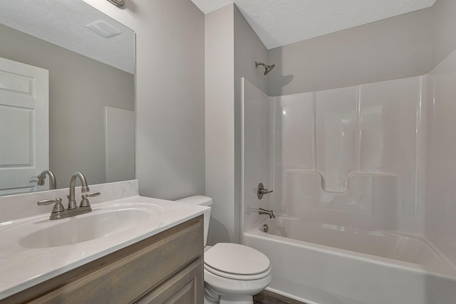 full bathroom featuring shower / bath combination, vanity, a textured ceiling, and toilet