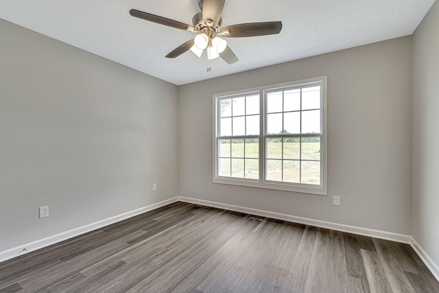 unfurnished room featuring dark wood-type flooring and ceiling fan