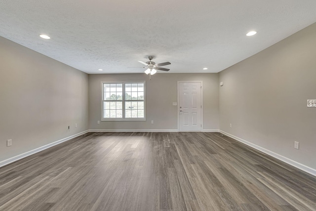 spare room featuring ceiling fan, dark hardwood / wood-style floors, and a textured ceiling