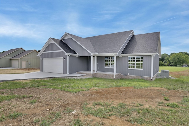 view of front facade with a garage, central AC, covered porch, and a front lawn