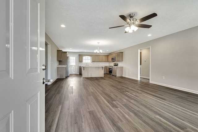 unfurnished living room featuring dark wood-type flooring, ceiling fan with notable chandelier, and a textured ceiling