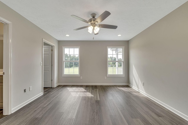 empty room featuring dark wood-type flooring, ceiling fan, and a textured ceiling