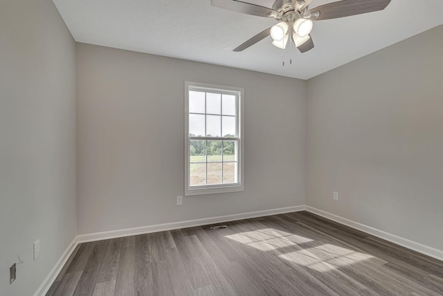 empty room with ceiling fan and dark hardwood / wood-style floors