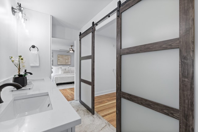 bathroom with dual vanity, ceiling fan, and hardwood / wood-style floors