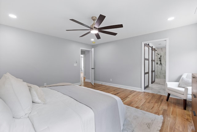 bedroom featuring connected bathroom, ceiling fan, and light wood-type flooring