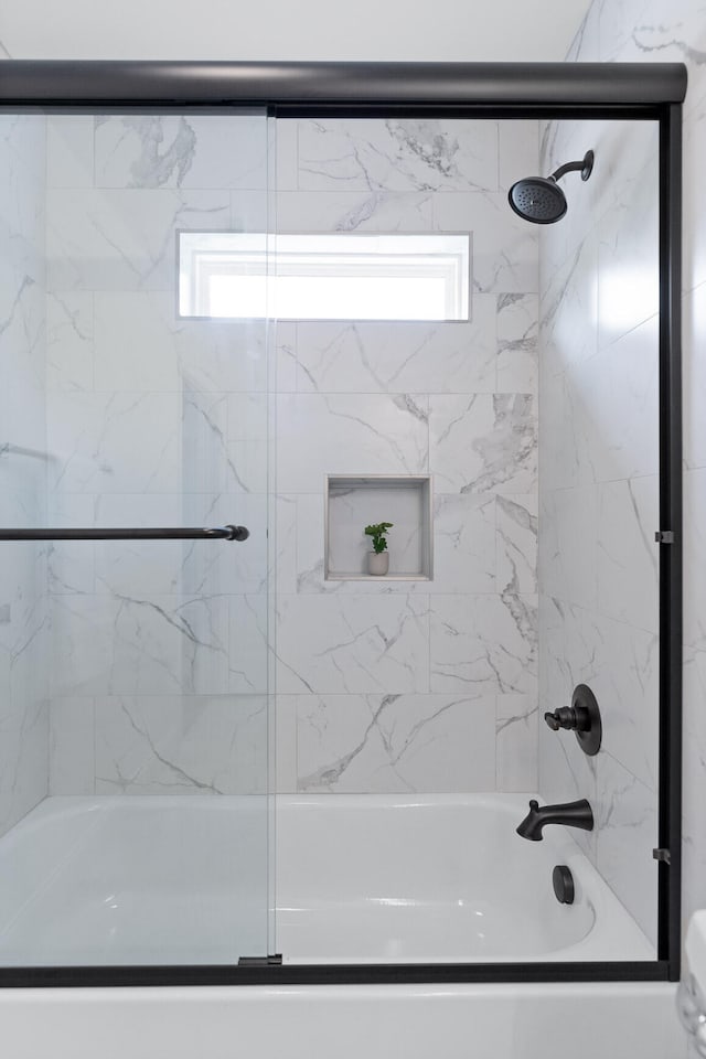 bathroom featuring bath / shower combo with glass door and plenty of natural light