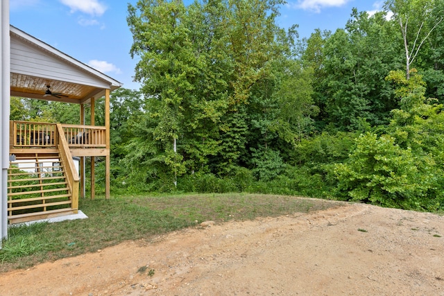 view of yard with a wooden deck and ceiling fan