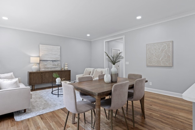 dining room featuring hardwood / wood-style floors and crown molding