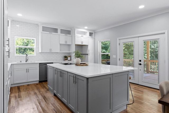 kitchen with dark hardwood / wood-style floors, a kitchen island, backsplash, ornamental molding, and gray cabinetry