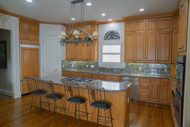 kitchen featuring dark wood-type flooring, sink, stainless steel appliances, and a kitchen island