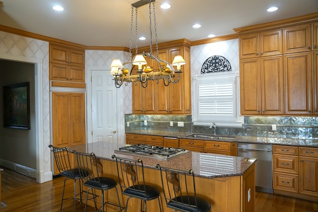 kitchen featuring decorative backsplash, sink, a center island, appliances with stainless steel finishes, and dark wood-type flooring