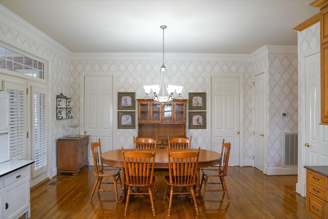 dining space with ornamental molding, wood-type flooring, and a chandelier