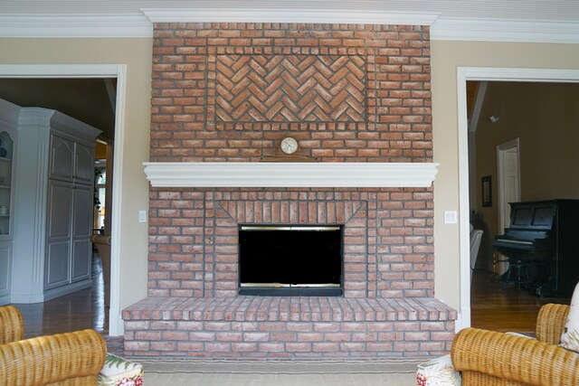 living room with hardwood / wood-style flooring, brick wall, and a fireplace