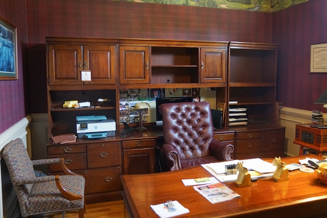 home office with wood-type flooring and built in desk