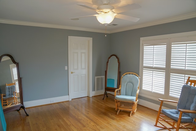 sitting room with ornamental molding, hardwood / wood-style flooring, and ceiling fan