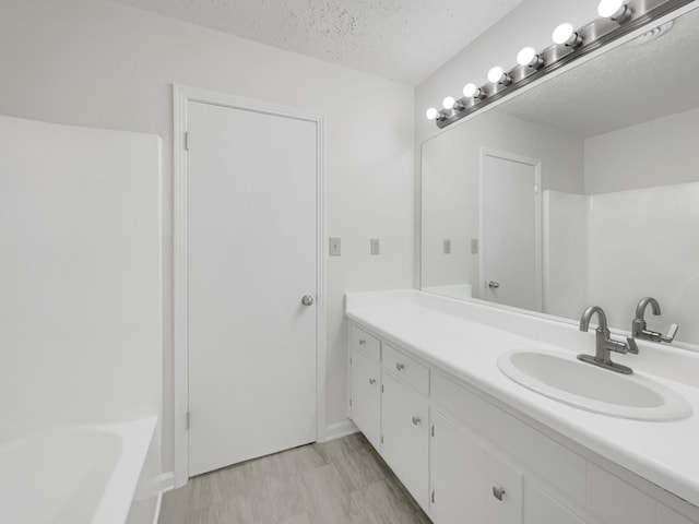 bathroom with a textured ceiling and vanity