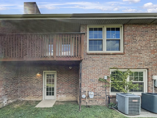 rear view of house featuring cooling unit and a balcony