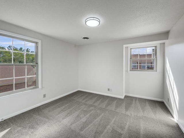 carpeted spare room featuring a textured ceiling