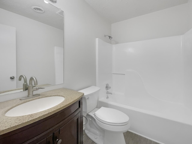 full bathroom featuring toilet, vanity, bathtub / shower combination, and a textured ceiling