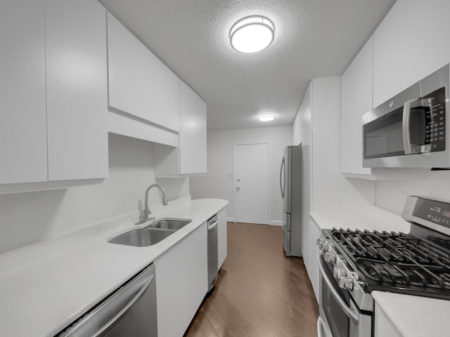 kitchen featuring white cabinets, sink, stainless steel appliances, and a textured ceiling