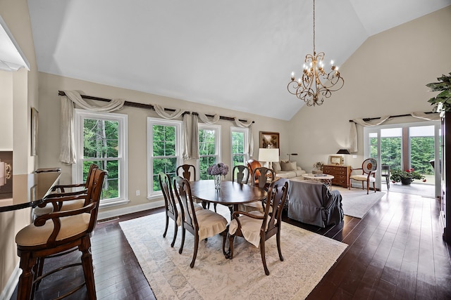 dining room with wood-type flooring, high vaulted ceiling, and an inviting chandelier