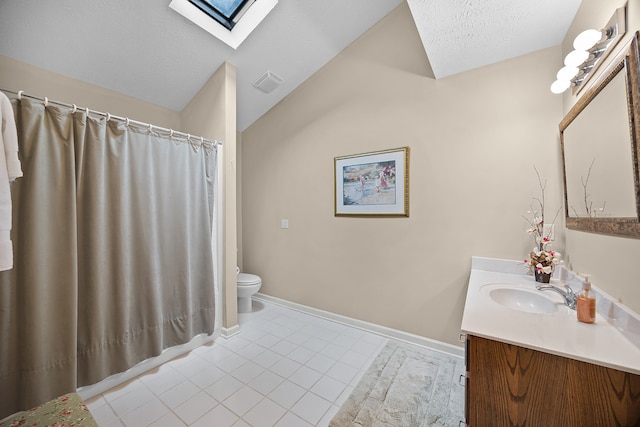 bathroom with vanity, tile patterned flooring, vaulted ceiling with skylight, and toilet