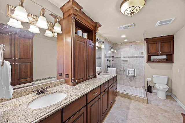 bathroom featuring tile patterned floors, toilet, a shower with door, and double vanity