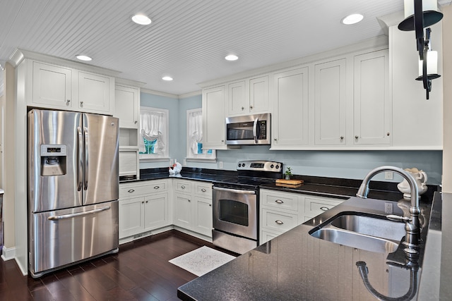 kitchen featuring appliances with stainless steel finishes, dark hardwood / wood-style flooring, white cabinets, and sink