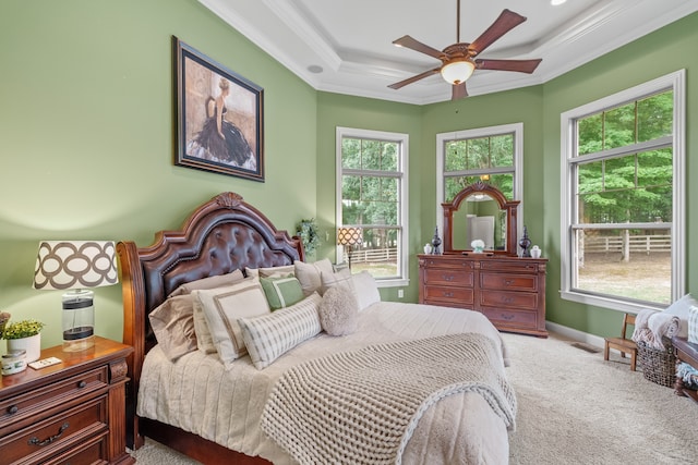 carpeted bedroom featuring multiple windows, ceiling fan, a raised ceiling, and ornamental molding