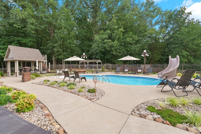 view of swimming pool with a gazebo, a patio area, and a water slide