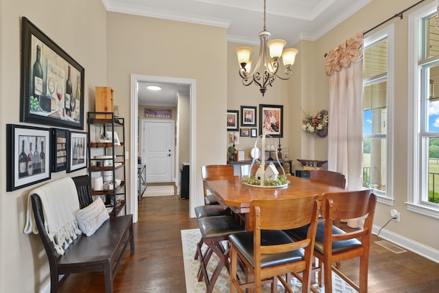 dining area with a notable chandelier, dark hardwood / wood-style flooring, and ornamental molding