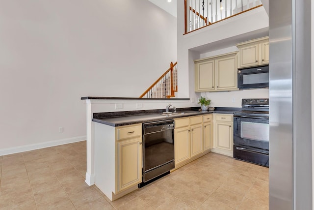 kitchen with a towering ceiling, black appliances, sink, kitchen peninsula, and cream cabinets