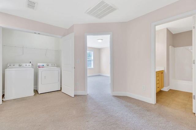 washroom featuring separate washer and dryer and light colored carpet