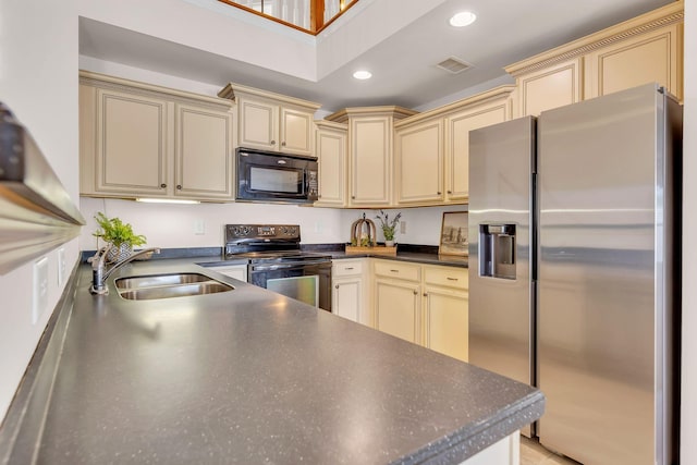 kitchen with sink, black appliances, cream cabinetry, and kitchen peninsula