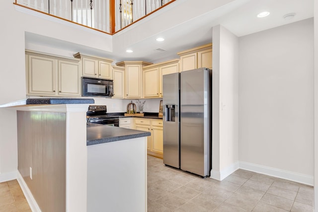 kitchen with black appliances, cream cabinetry, a high ceiling, and light tile patterned flooring