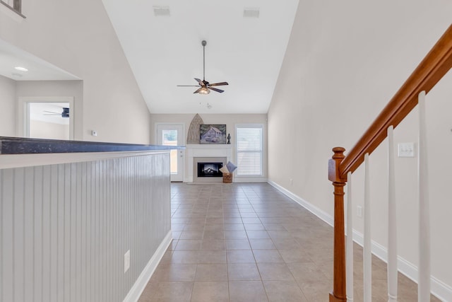 unfurnished living room with lofted ceiling, light tile patterned floors, and ceiling fan