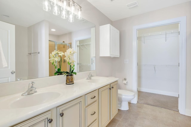 bathroom featuring walk in shower, tile patterned floors, vanity, and toilet