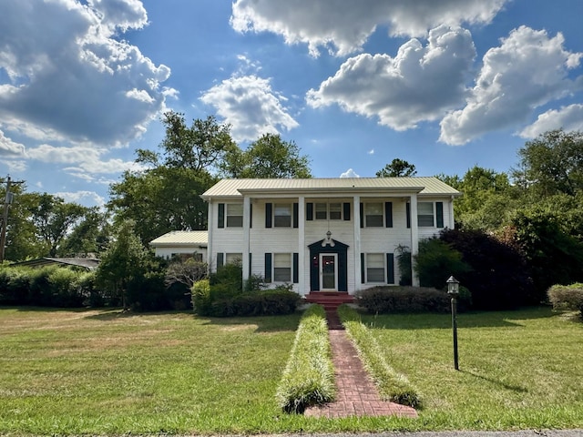 greek revival house with a front yard and metal roof