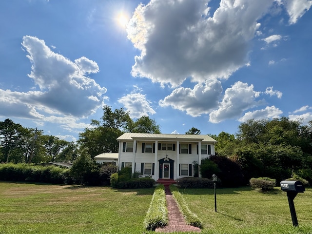 colonial-style house featuring a front yard