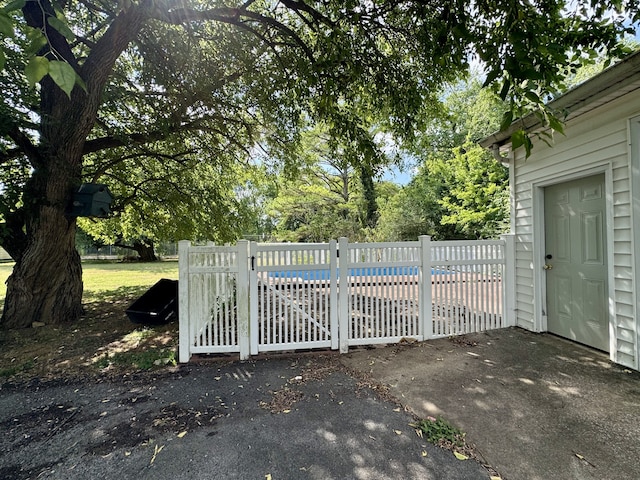 view of gate with a fenced in pool