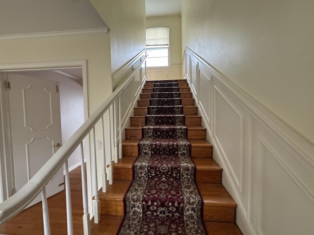 stairway with crown molding and hardwood / wood-style floors