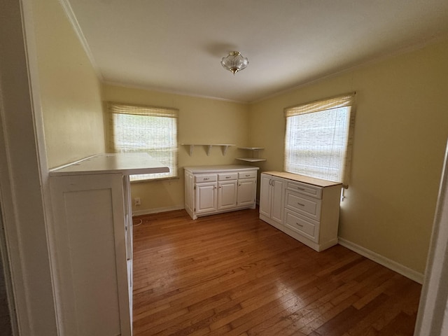 kitchen featuring crown molding, light hardwood / wood-style flooring, and white cabinets