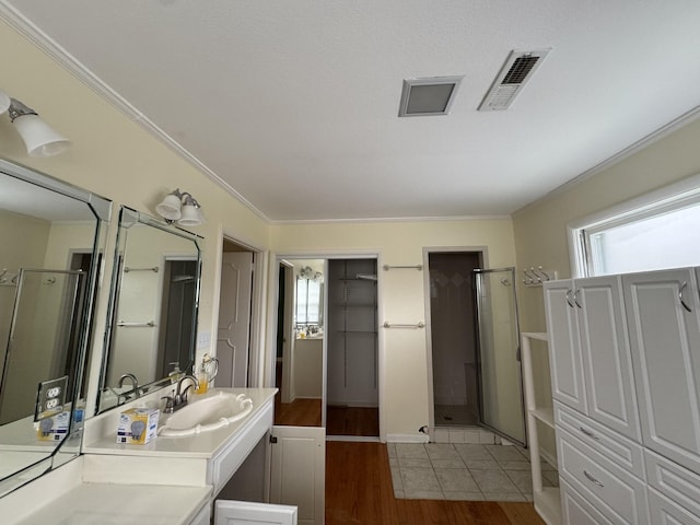 bathroom with hardwood / wood-style floors, plenty of natural light, walk in shower, and vanity