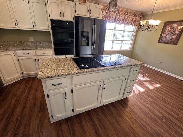 kitchen with pendant lighting, dark wood-type flooring, white cabinetry, black appliances, and crown molding