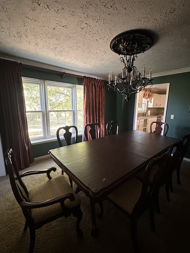 dining room featuring a notable chandelier, a textured ceiling, ornamental molding, and carpet