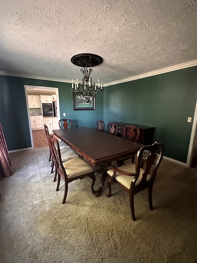 dining space with carpet floors, a textured ceiling, crown molding, and an inviting chandelier